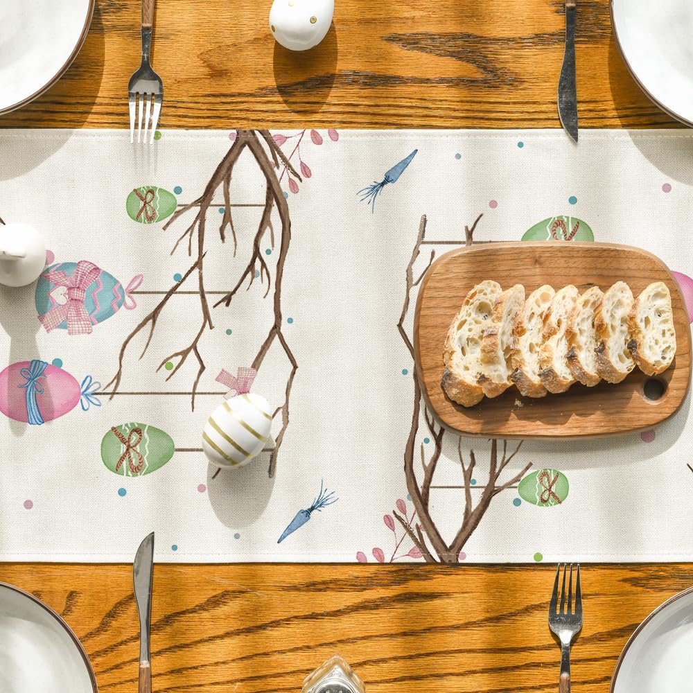 Easter table runner with painted eggs and branches on a wooden table with plates and bread