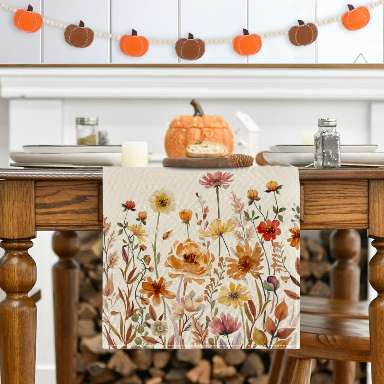 Fall floral table runner with autumn leaves pattern on a wooden dining table with place settings