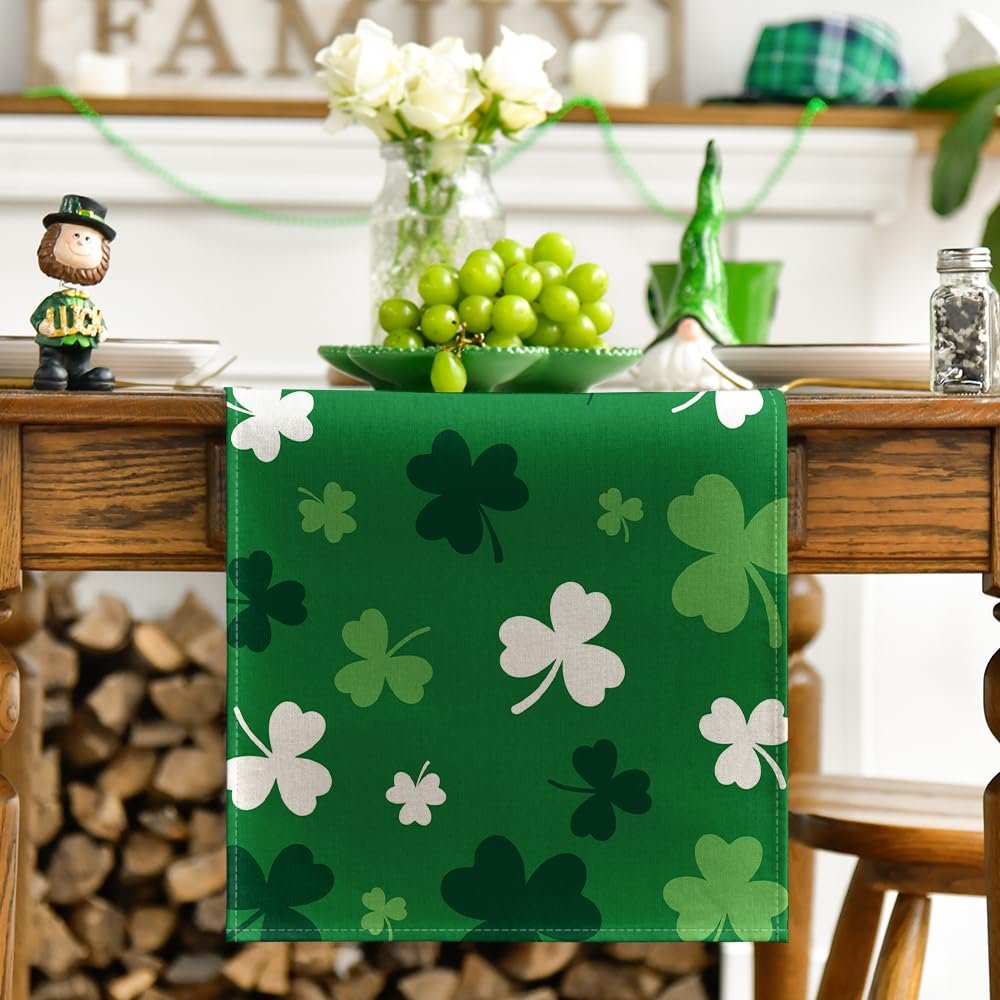 Green St. Patrick's Day table runner with shamrock pattern, laid on a wooden table with decorative items.