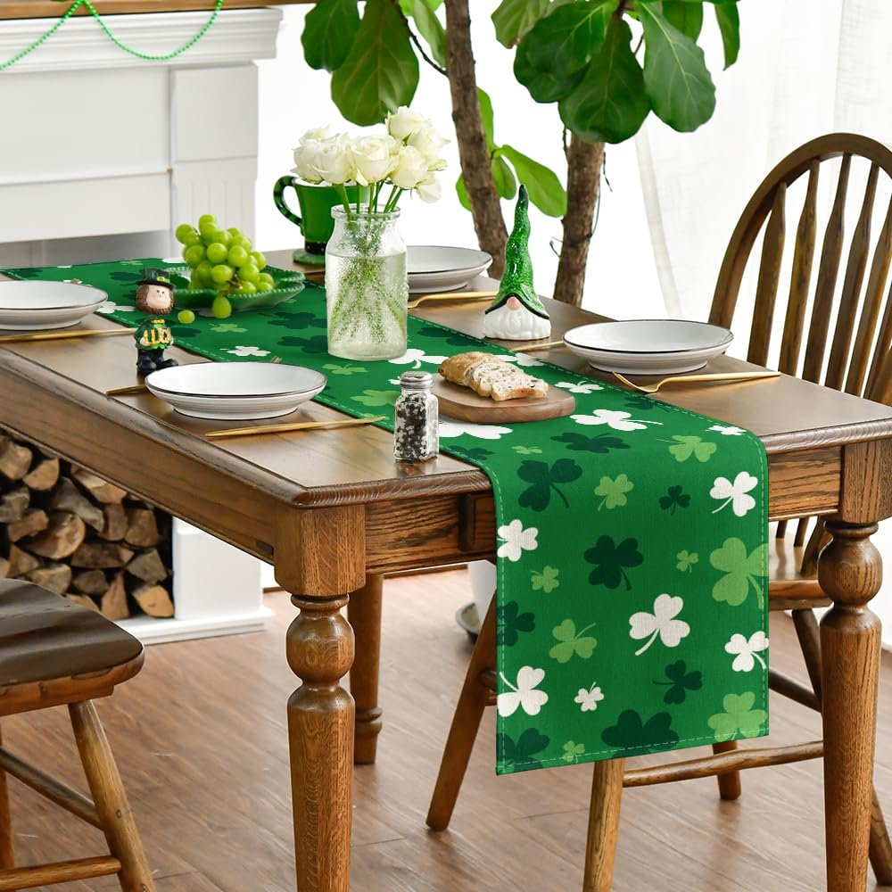 Green St. Patrick's Day table runner with shamrock pattern laid on a wooden dining table set for a meal.