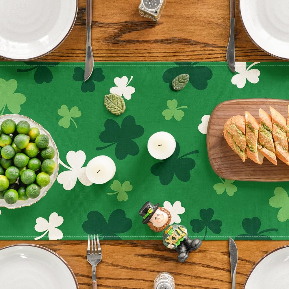 Green St. Patrick's Day table runner with shamrock pattern, set on a wooden table with place settings, bread, and limes.