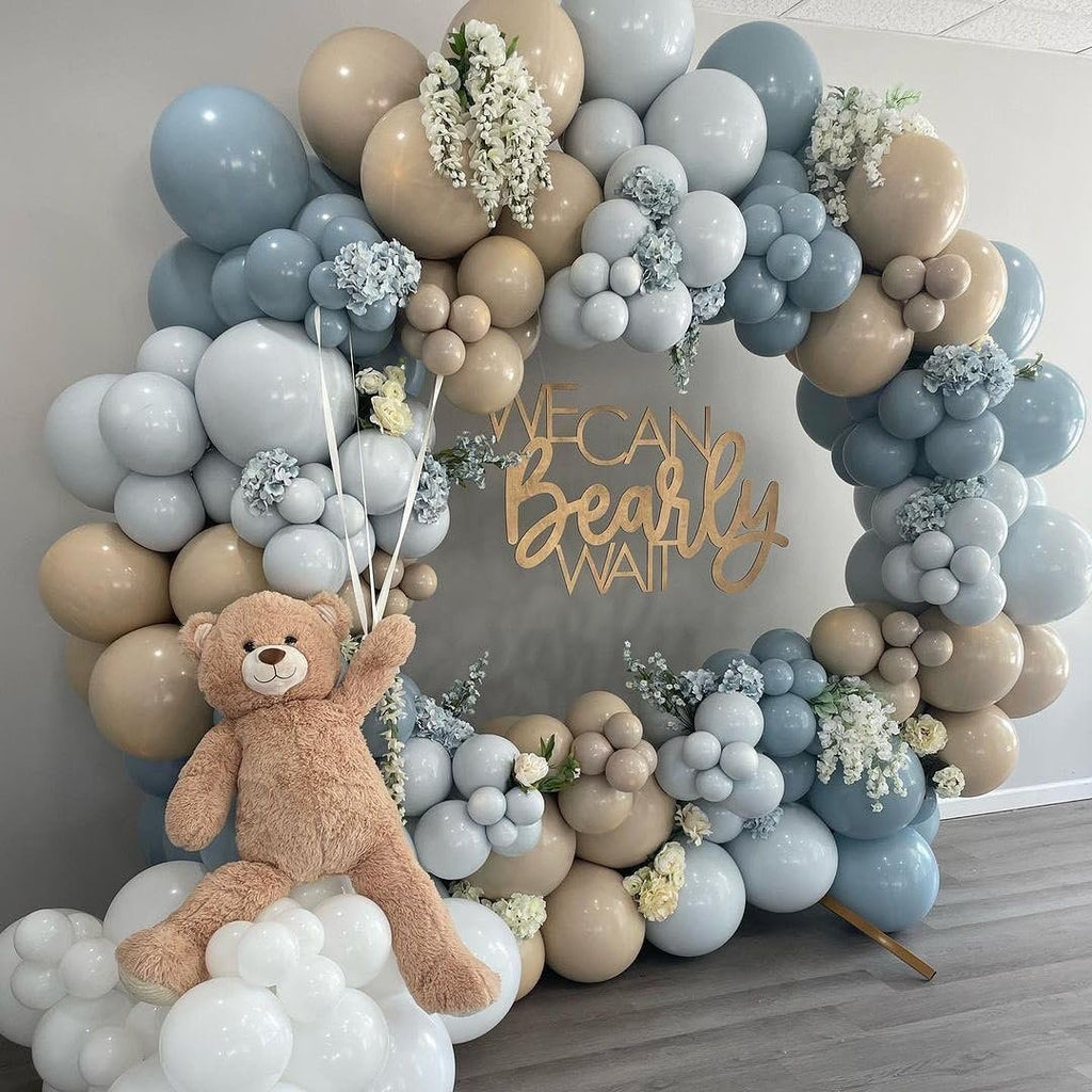 Balloon arch with a teddy bear and wooden sign that says 'We Can Bearly Wait'