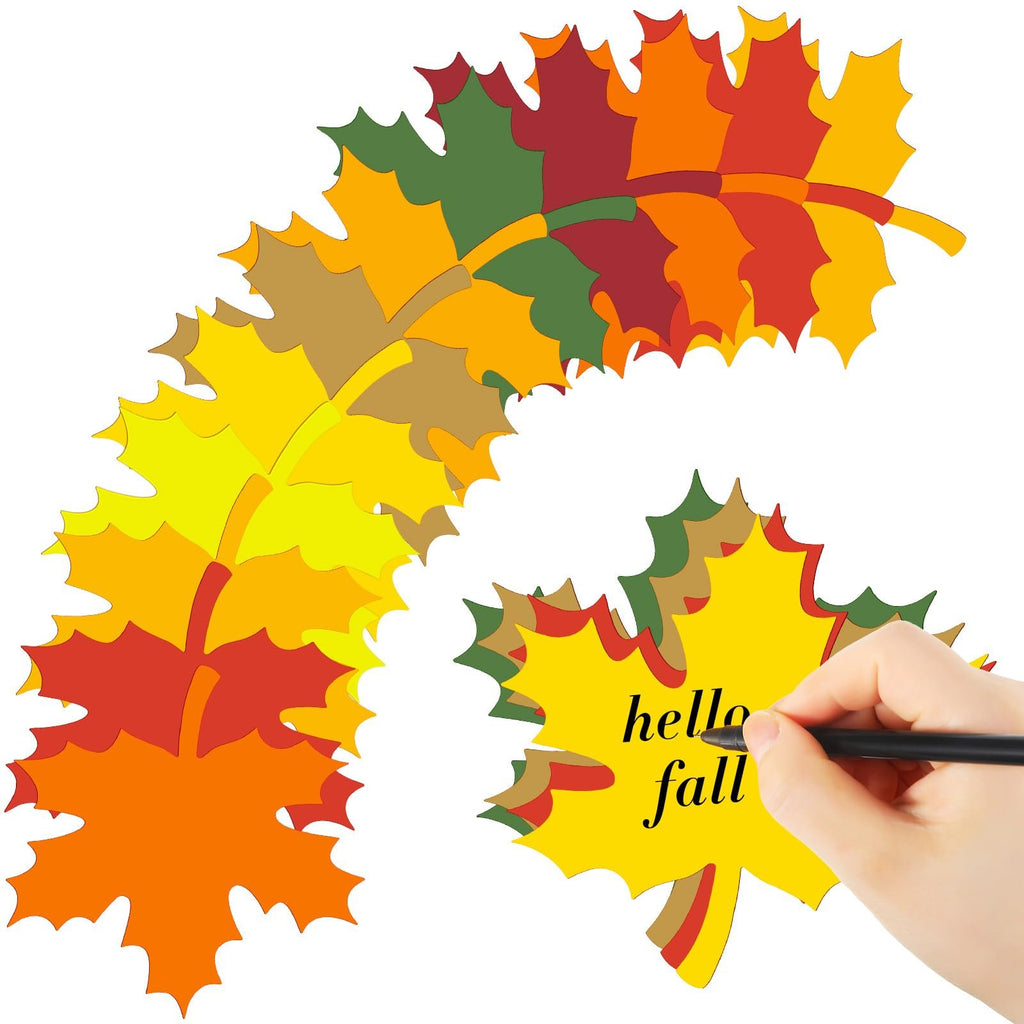 Assorted paper maple leaf cutouts in fall colors, with a hand writing 'hello fall' on one leaf.