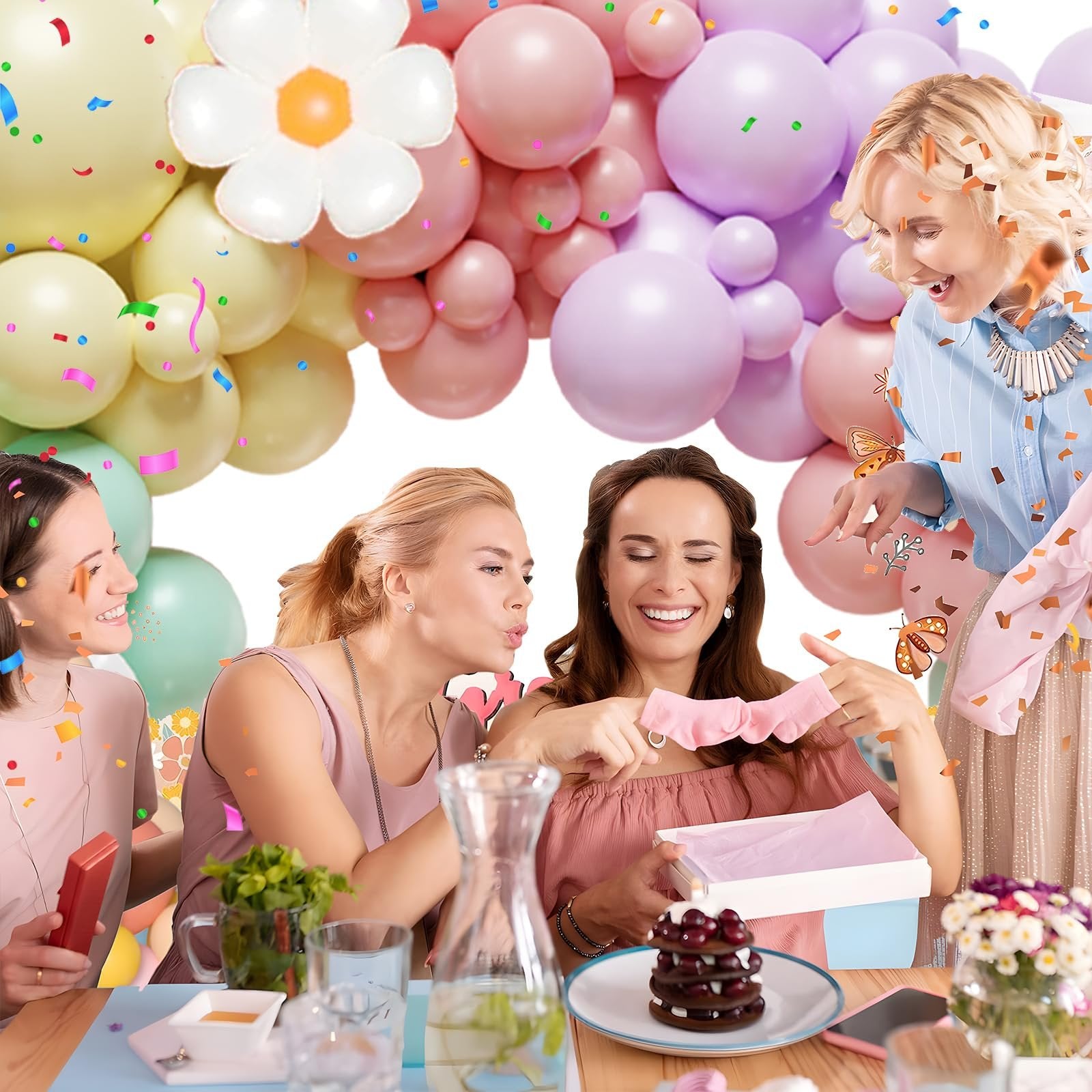 Four women celebrating with a pastel balloon arch and confetti, one woman opens a gift.