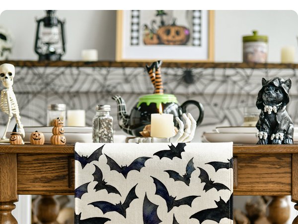 Halloween table runner with black bats pattern on a decorated dining table with skeleton and cat figurines