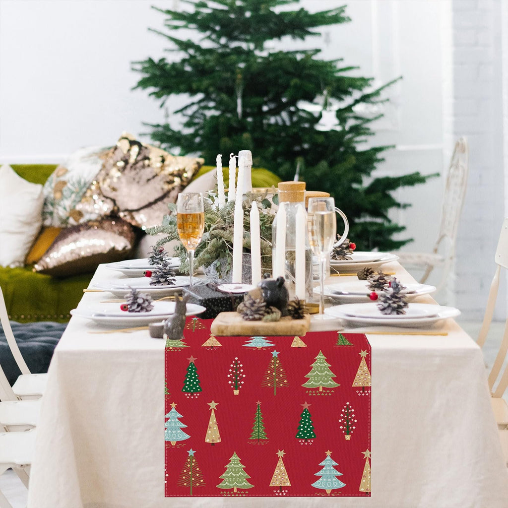Christmas table runner with red background and assorted green and gold Christmas trees pattern