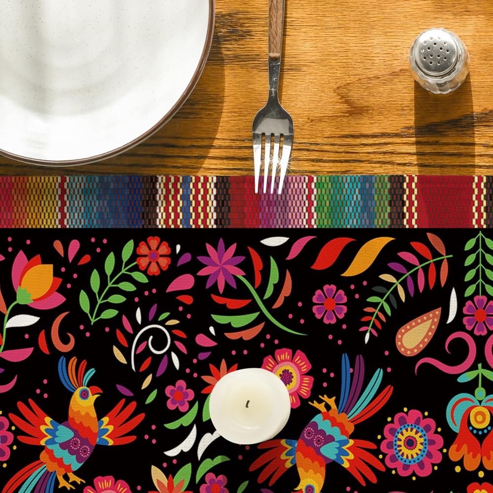 Table setting with a colorful Day of the Dead serape table runner featuring birds and flowers, a plate, fork, and salt shaker.