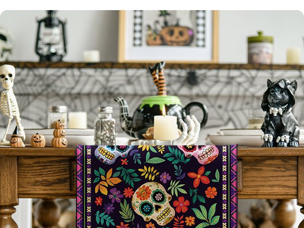 Sugar skull and floral patterned table runner on a wooden table with Halloween decorations