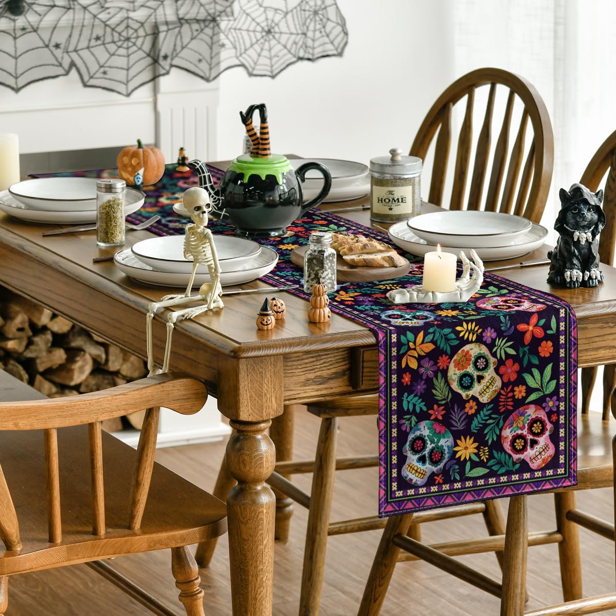 Dia de los Muertos table runner with sugar skulls and floral patterns on a dining table setting