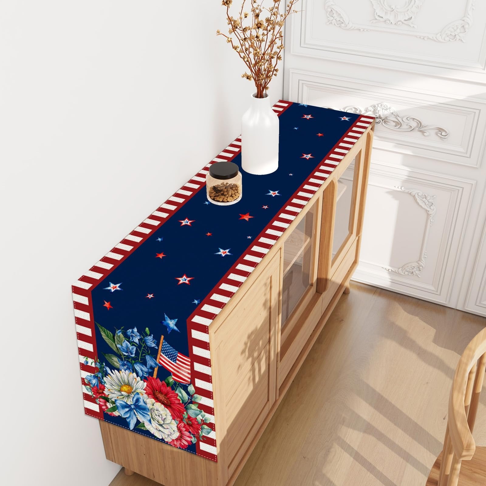American flag and floral print table runner with red and white striped edges on a wooden cabinet