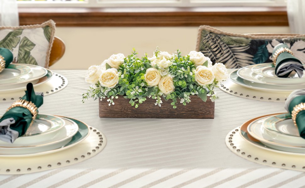 Wooden centerpiece box with artificial yellow roses and eucalyptus on a dining table setting
