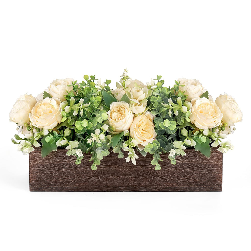 Wooden centerpiece box filled with artificial yellow roses and green eucalyptus leaves against a white background.