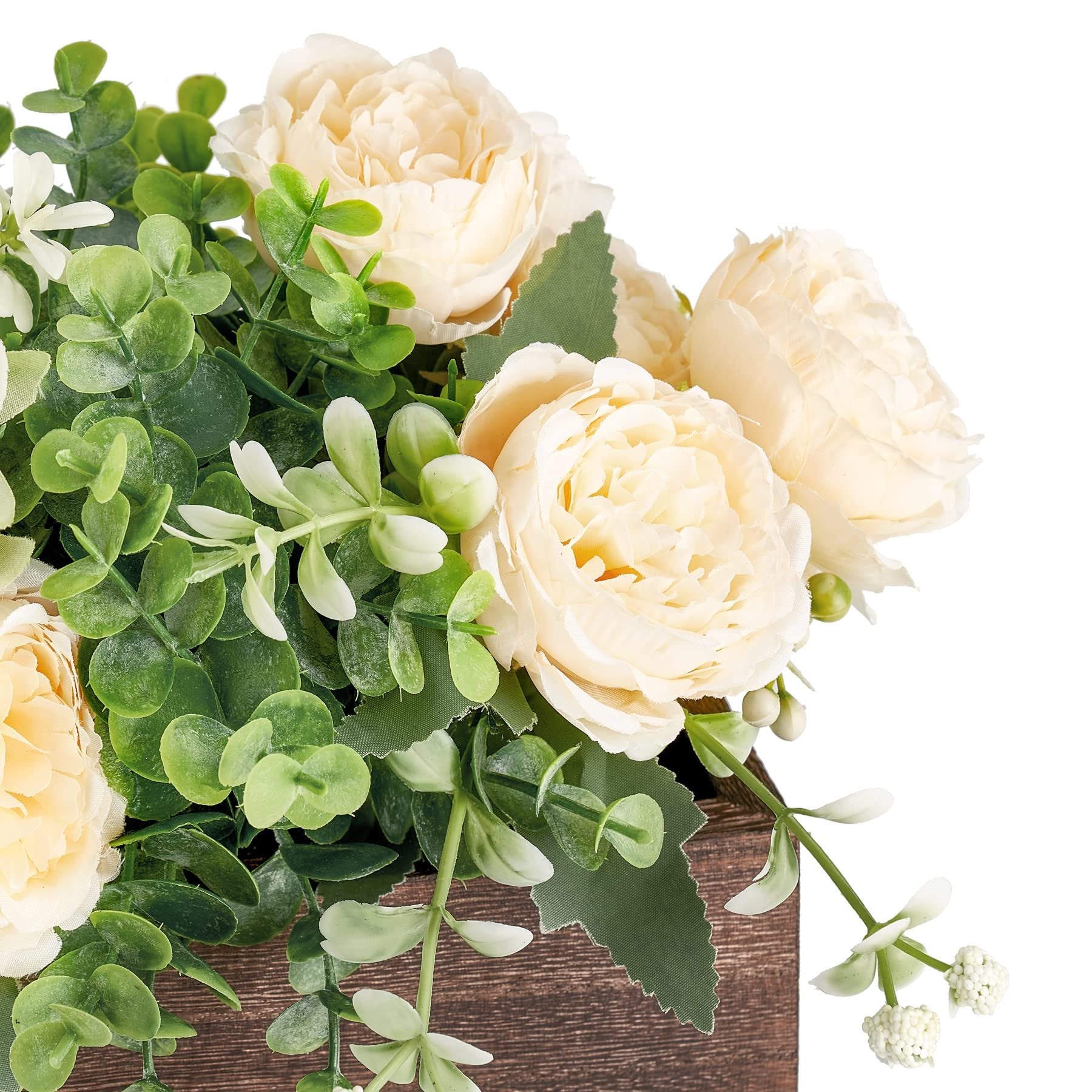 Close-up of a wooden centerpiece box filled with artificial cream peonies and eucalyptus greenery.