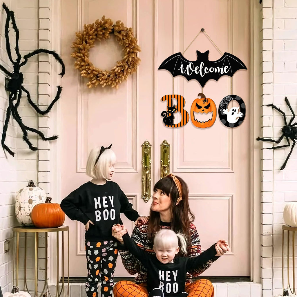 Family celebrating Halloween with a BOO door sign and decorations