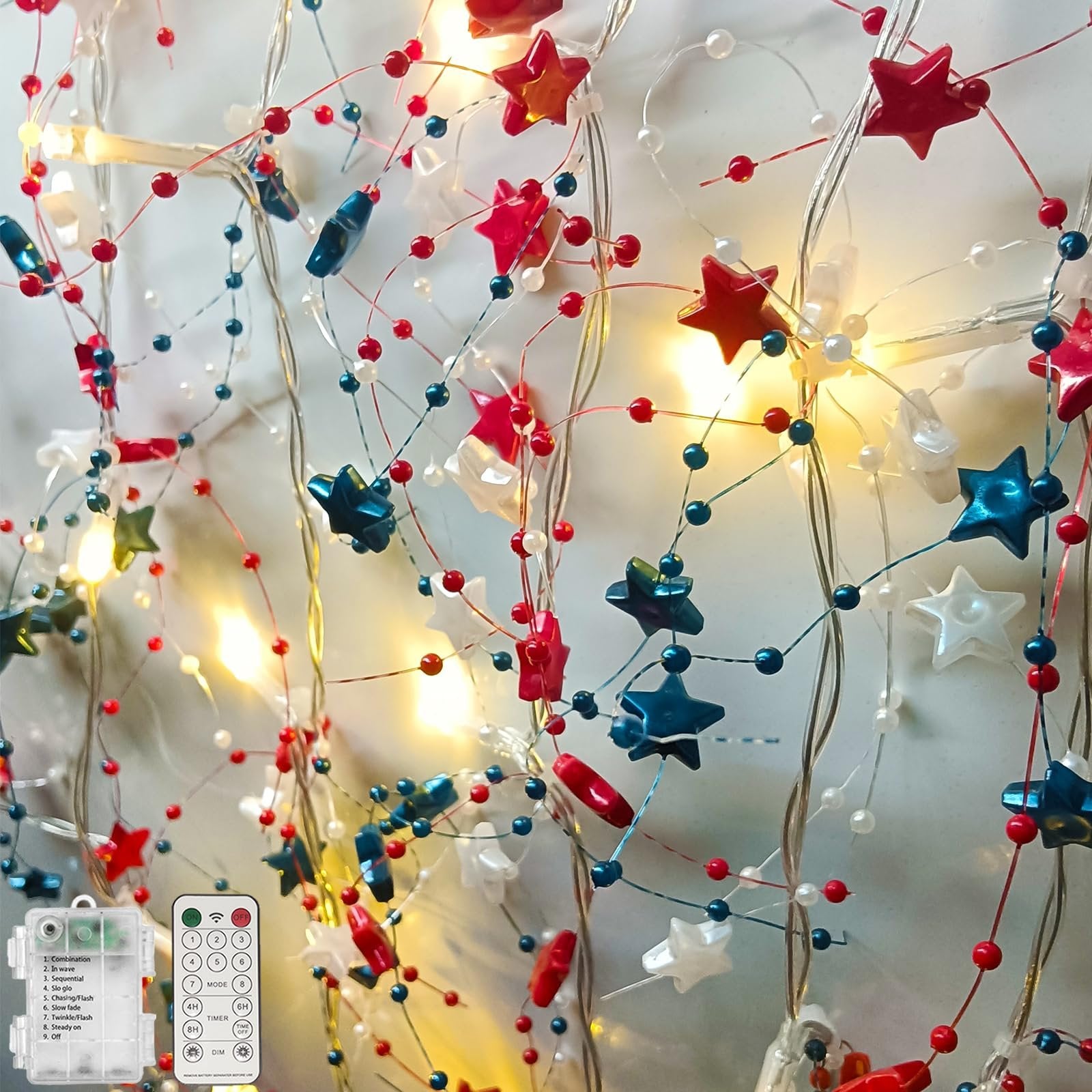 Red, white, and blue star garland with warm white LED lights and beads, includes remote and battery pack.
