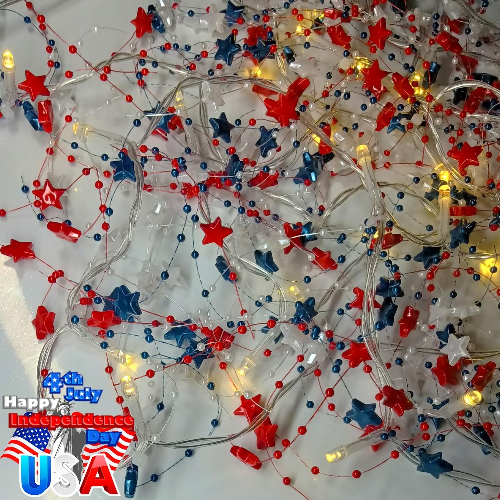 Red, white, and blue star garland with warm white LED lights, close-up view of tangled string lights.