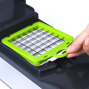 Close-up of a hand inserting a green vegetable chopper blade into a gray base unit. The blade has a grid pattern for dicing.