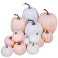 Assorted white and pink faux foam pumpkins of various sizes arranged together on a white background.