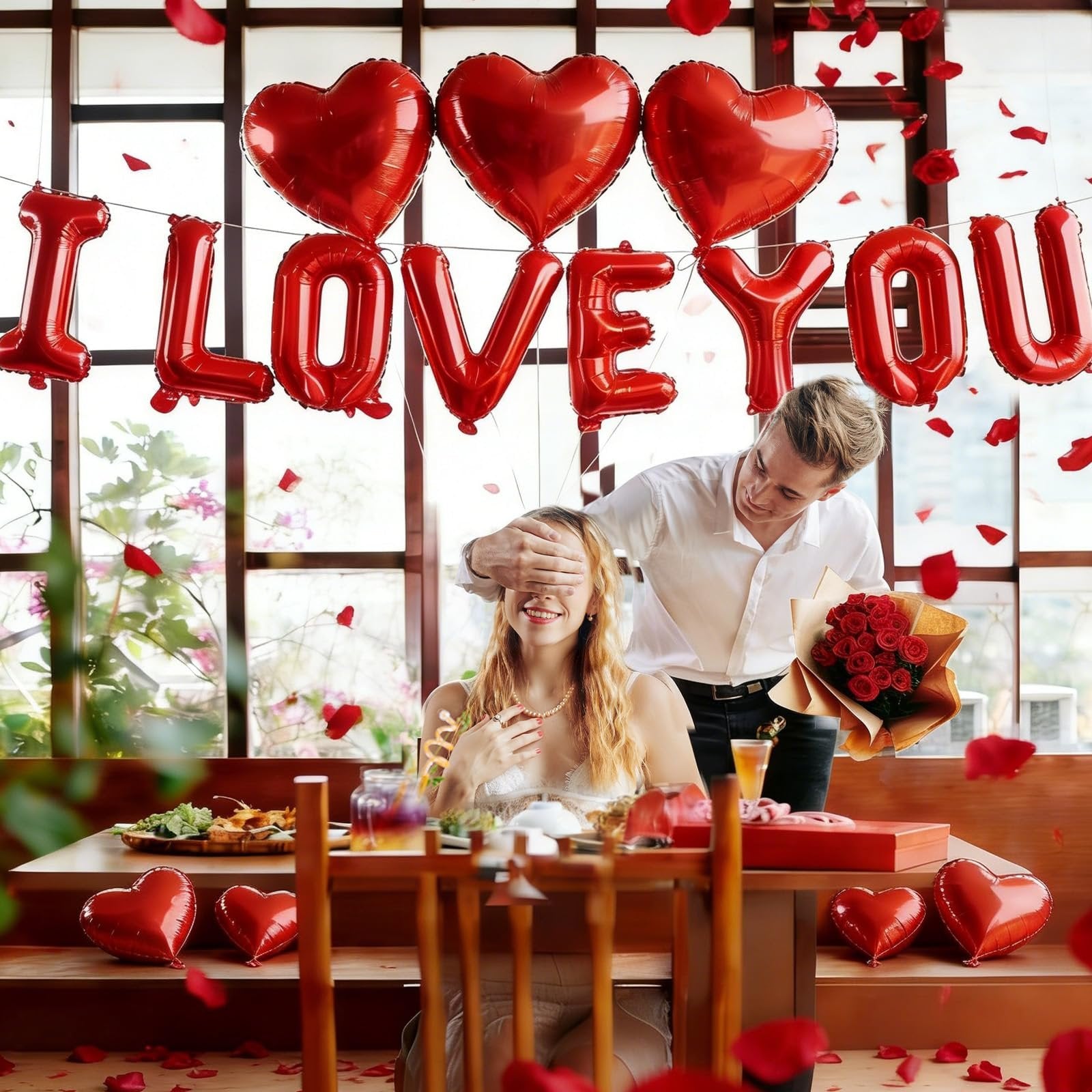 Couple celebrating Valentine's Day with 'I LOVE YOU' balloons and rose petals