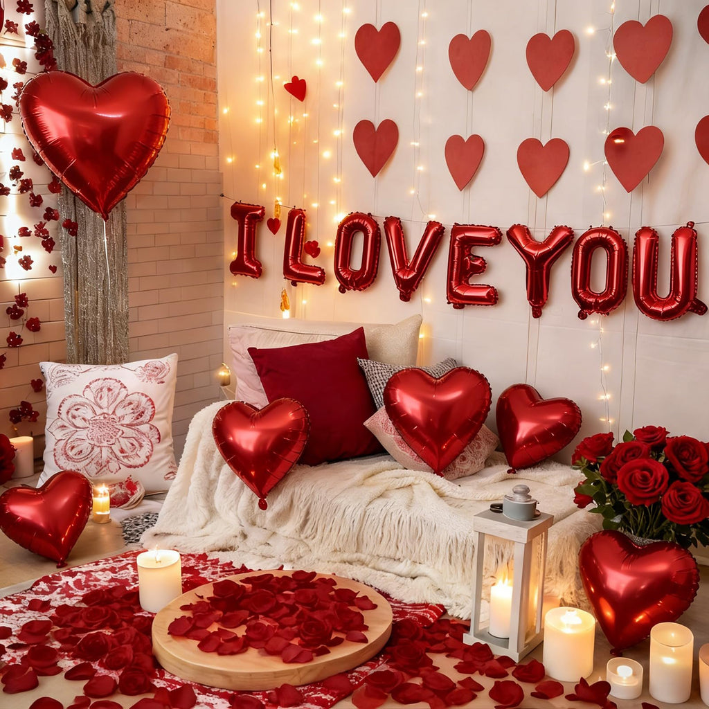 Romantic bedroom setup with red heart balloons, 'I LOVE YOU' balloon banner, rose petals, and candles.