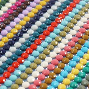 Close-up of colorful diamond painting drills arranged in rows on a blue background.
