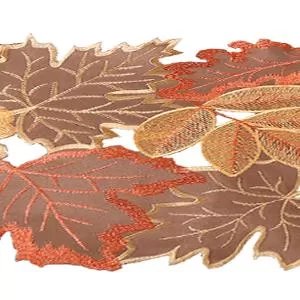 Close-up of a brown and orange embroidered fabric table runner with fall leaf patterns, on a white background.
