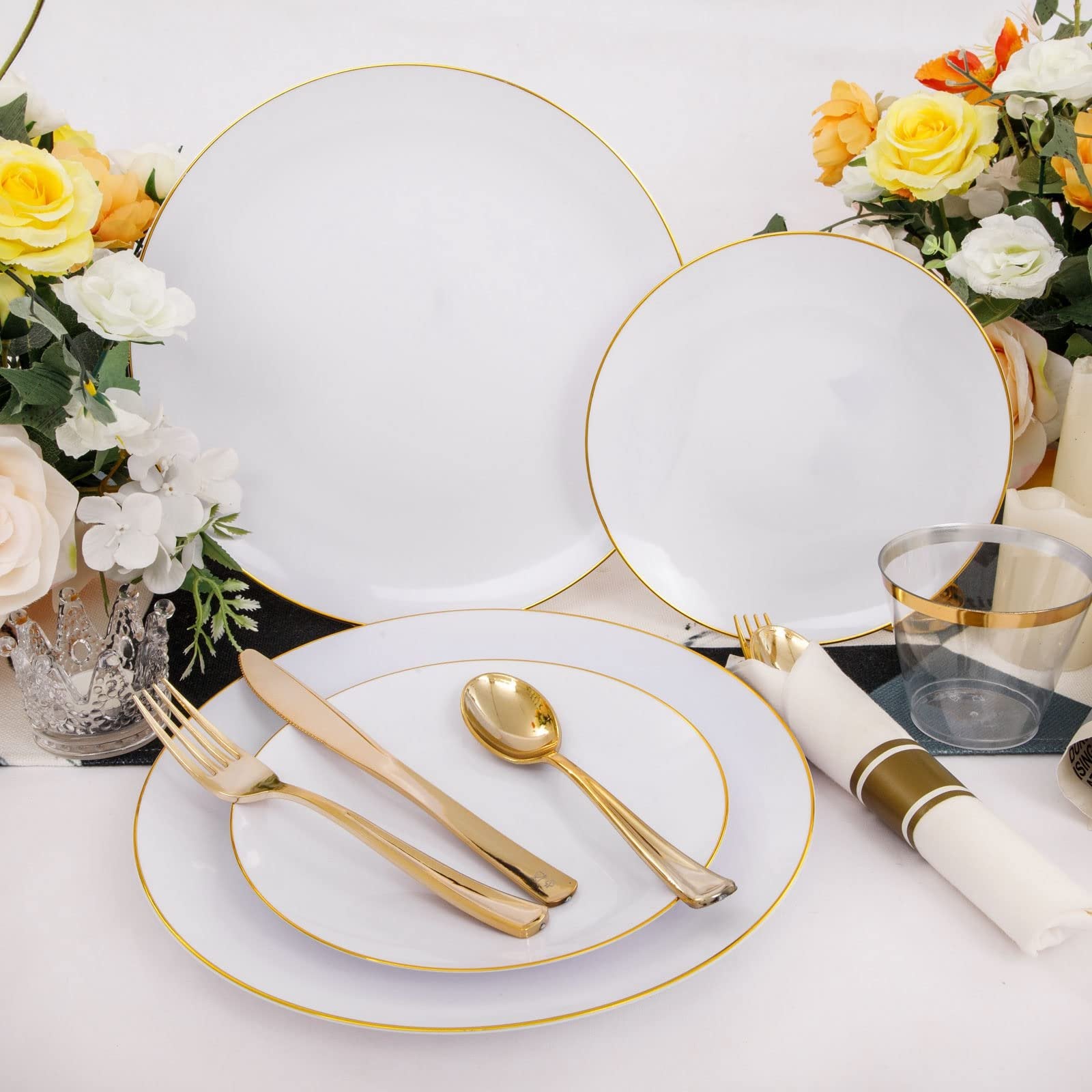 White and gold rim disposable dinnerware set with plates, cutlery, and cups arranged with flowers