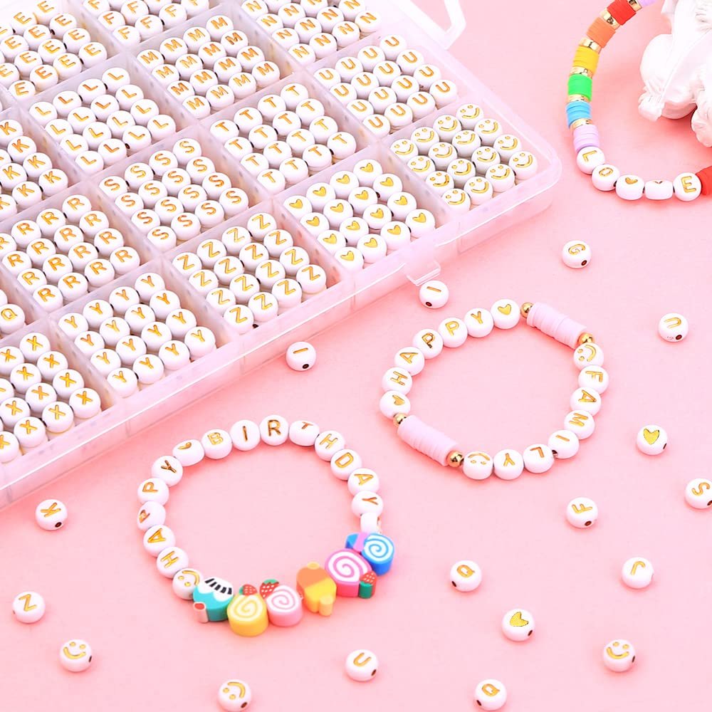 Round letter beads and bracelets with letter beads, arranged on a pink surface. Includes a clear plastic organizer filled with letter beads.
