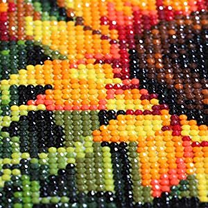 Close-up of a 5D diamond painting kit showing colorful beads forming a sun and moon design.