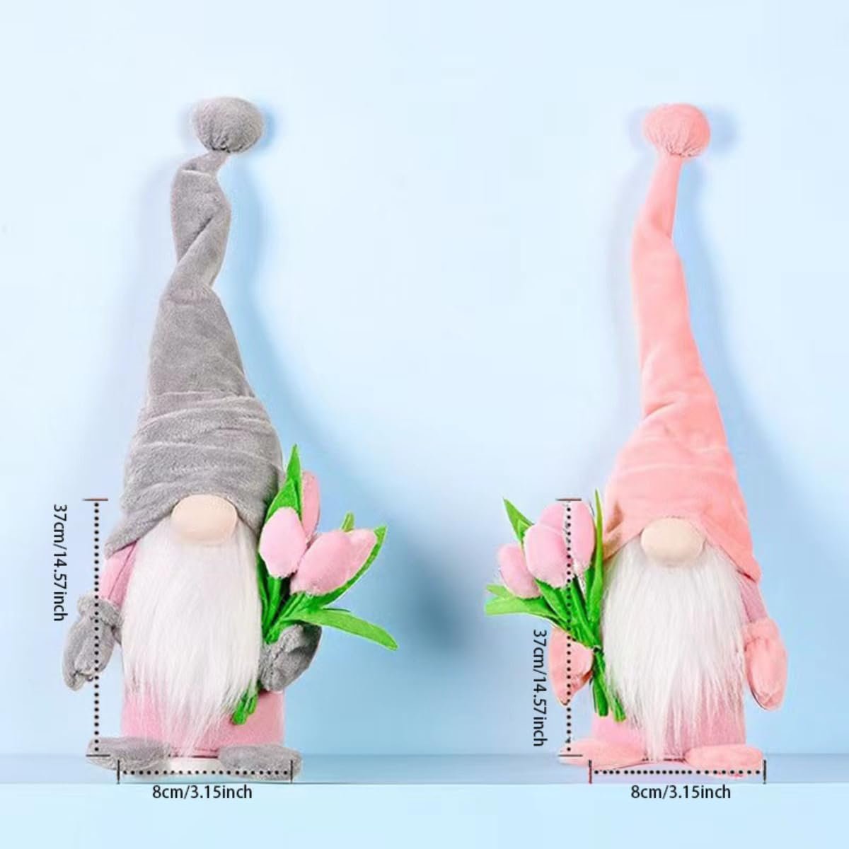 Two plush gnome dolls, one grey and one pink, holding pink tulips. Dimensions are shown with measurement lines.