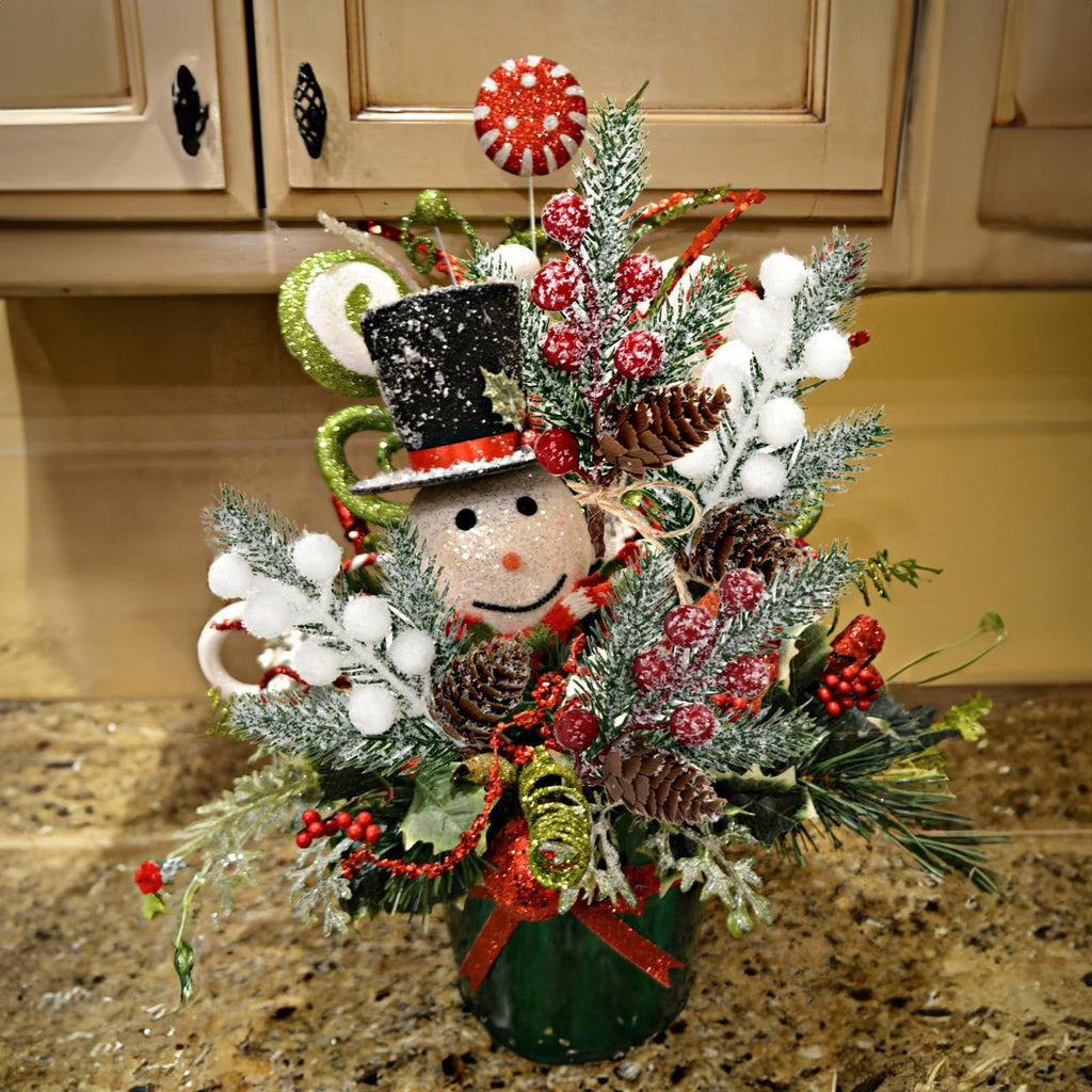 Christmas snowman floral arrangement with pinecones, red berries, and frosted pine needles in a green pot.
