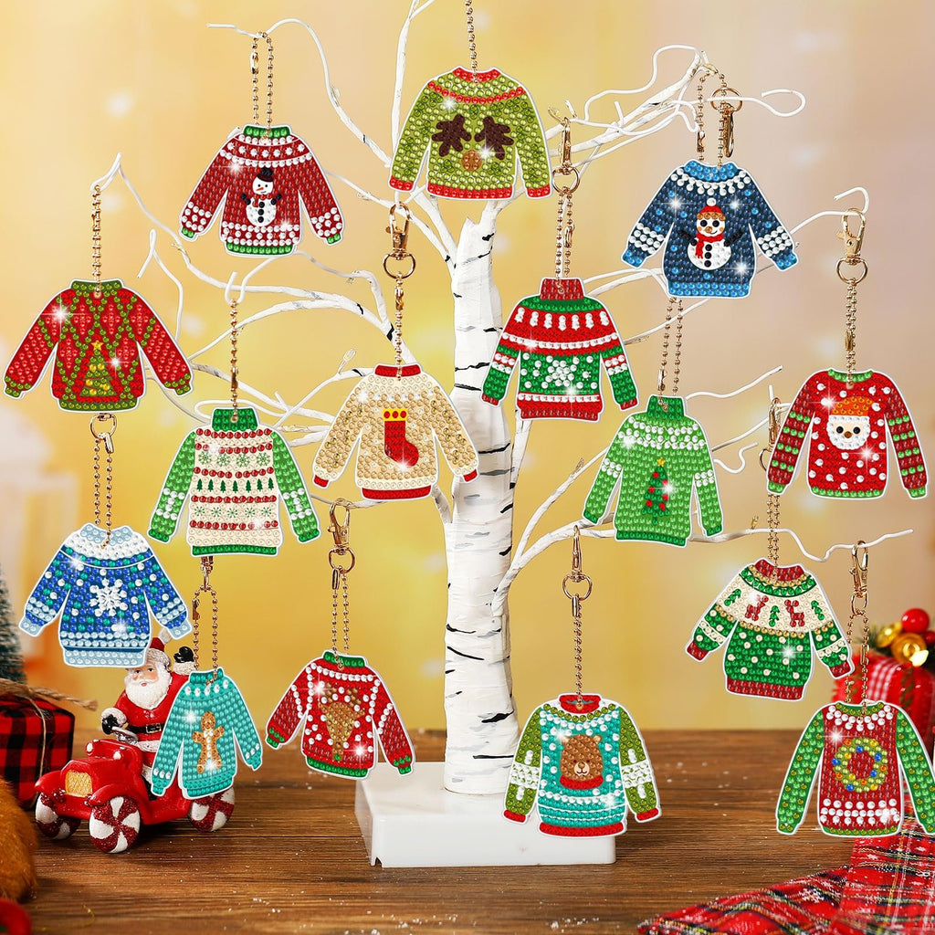 Christmas ugly sweater diamond painting keychain ornaments displayed on a white tree branch, featuring various festive designs like snowmen, reindeer, and Santa.