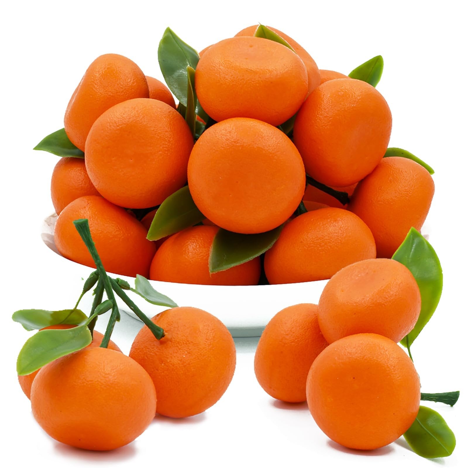 Pile of mini artificial oranges with green leaves, some in a white bowl and some scattered around.