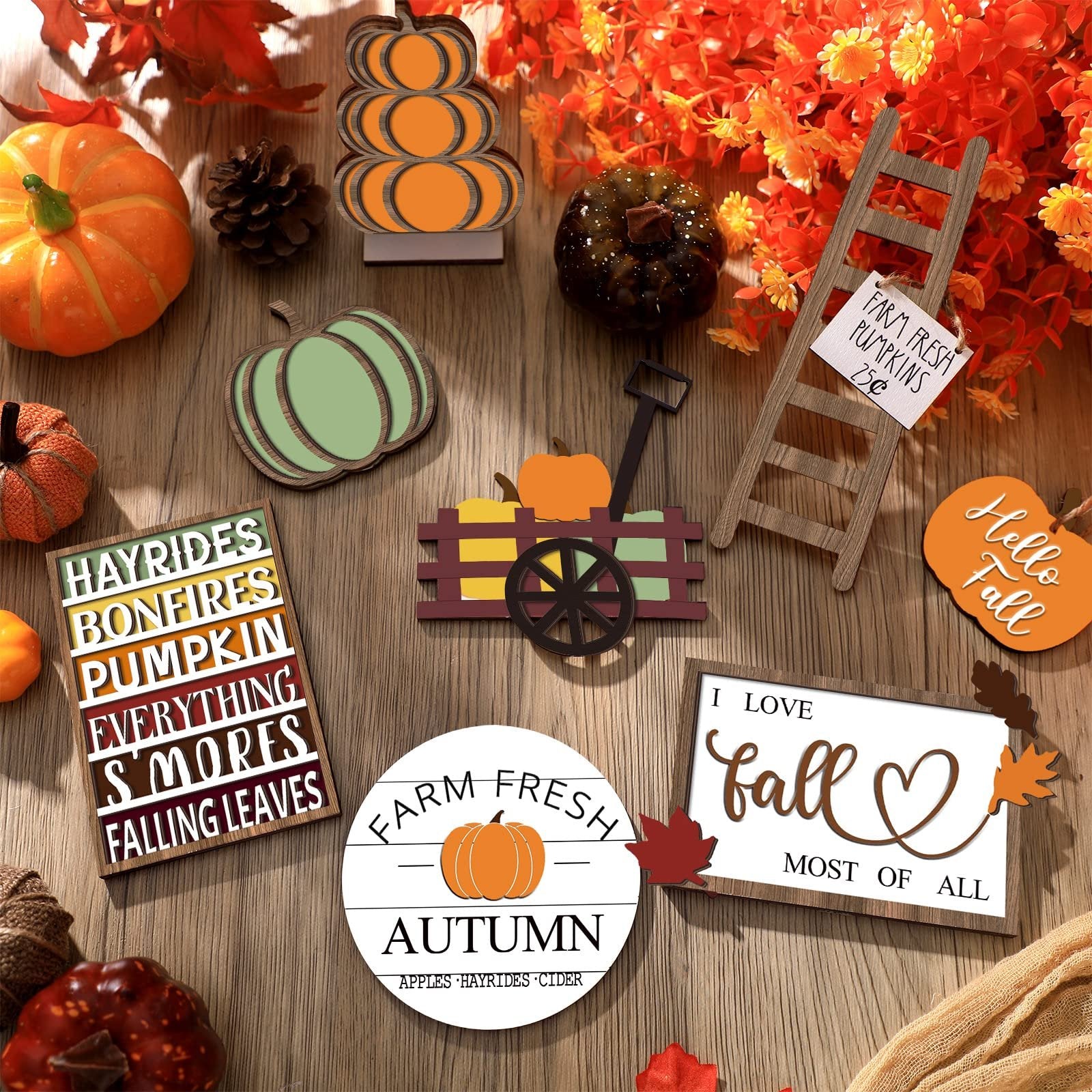 Fall themed wooden decor set including pumpkins, signs with text, and a small ladder on a wooden surface.