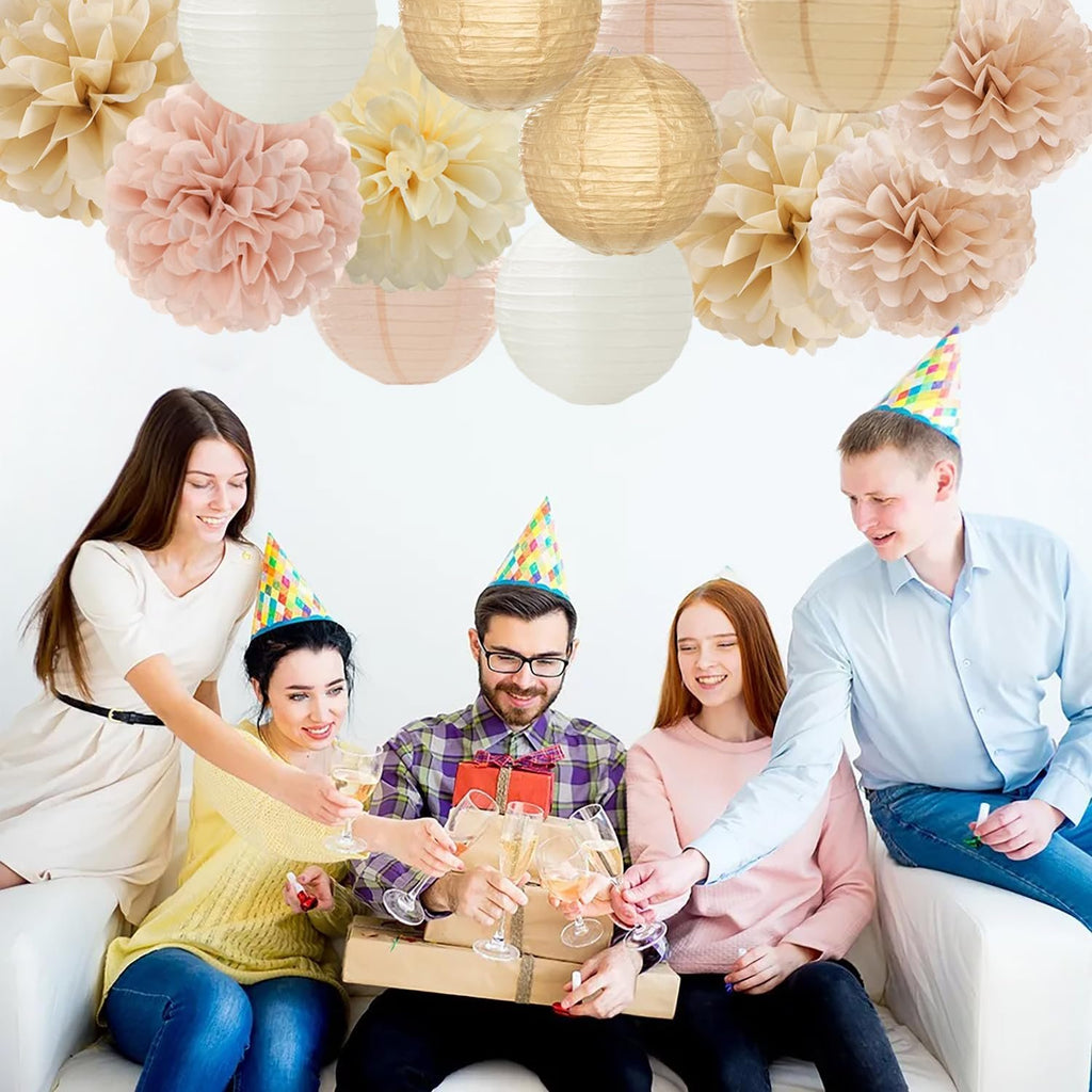 Group of friends celebrating with champagne and gifts, decorated with paper pom poms and lanterns.