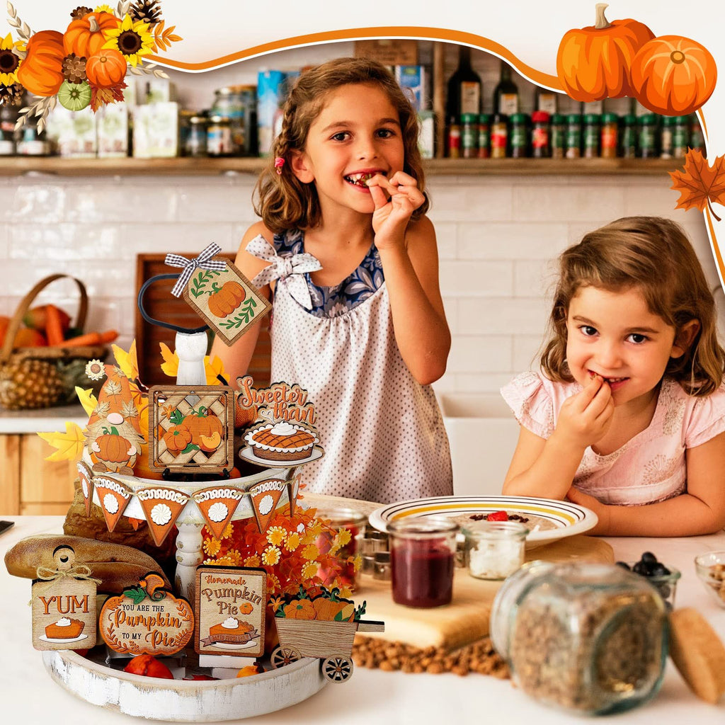Two young girls smiling and eating at a kitchen counter with a Thanksgiving tiered tray decor set.