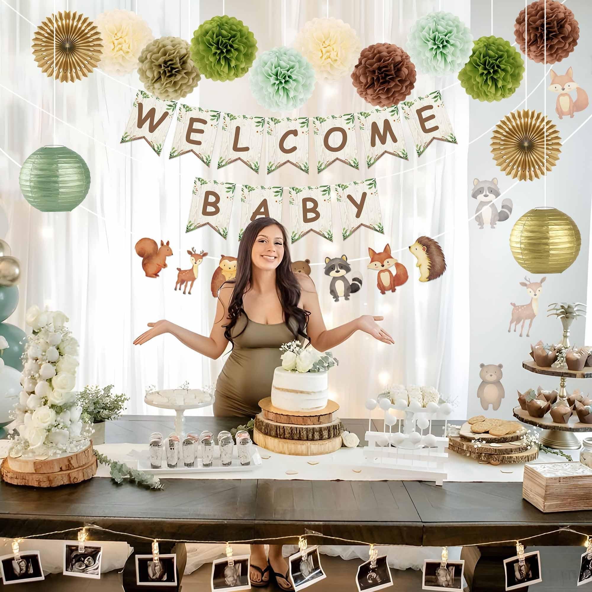 Pregnant woman at a woodland baby shower with cake and decorations, including a 'Welcome Baby' banner and animal cutouts.