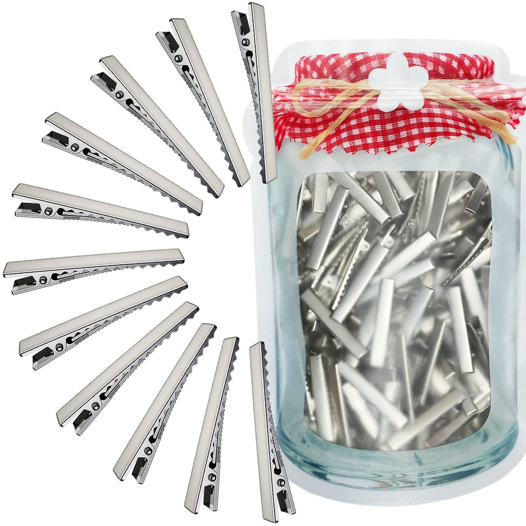 Silver alligator hair clips arranged in a circle and a clear pouch filled with clips, tied with gingham fabric and twine.