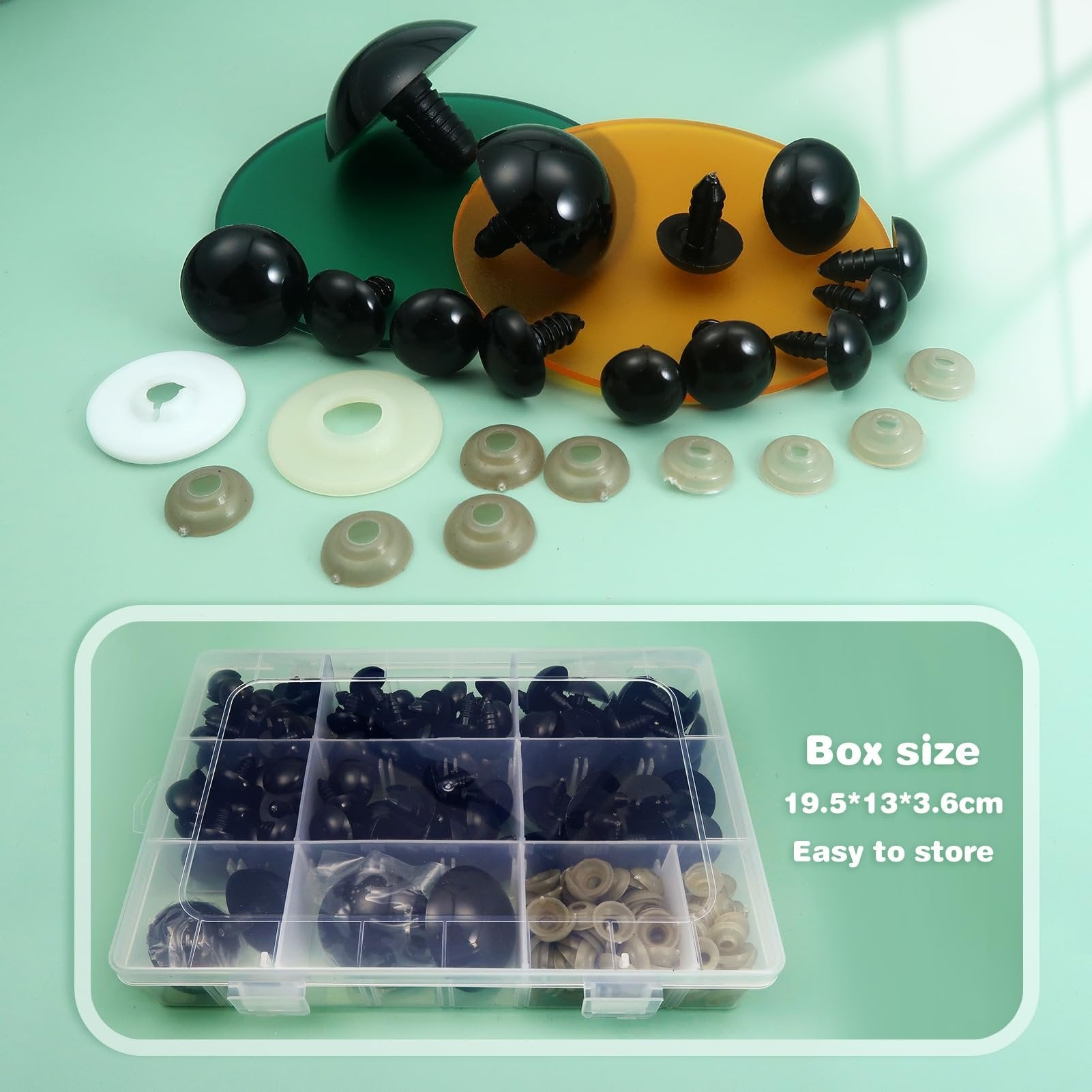 Assorted black plastic safety eyes and washers scattered on a green surface, with a clear storage box of eyes and washers below.