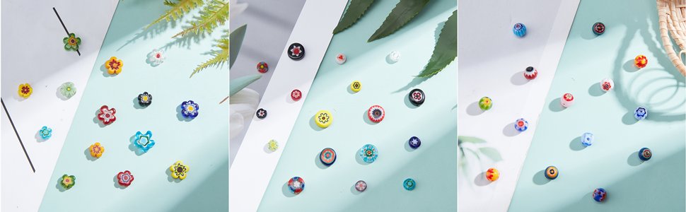 Assortment of colorful millefiori glass beads scattered on a light blue and white surface with green leaves and shadows.