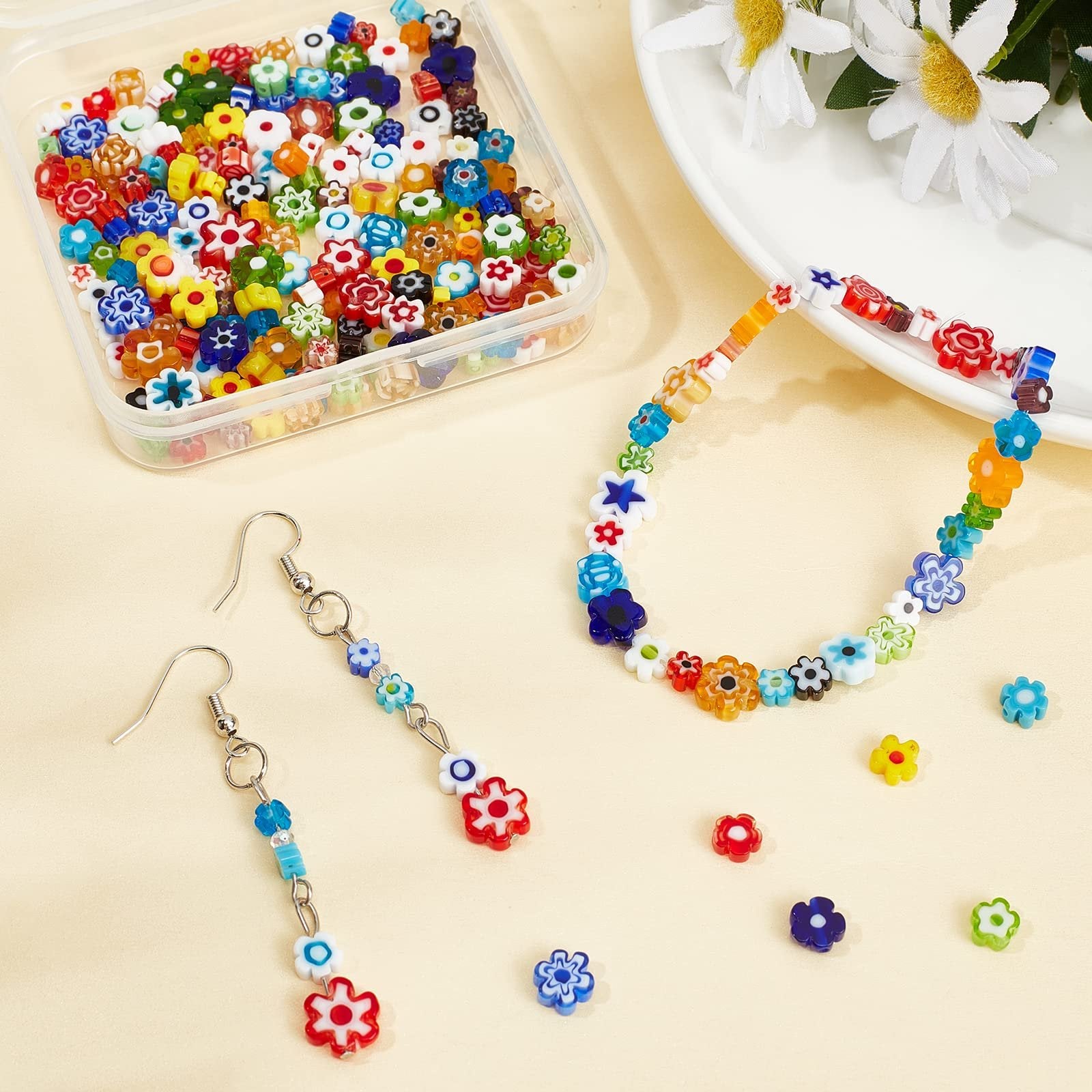 Assortment of colorful millefiori glass beads in a clear container, with a finished bracelet and earrings displayed alongside.