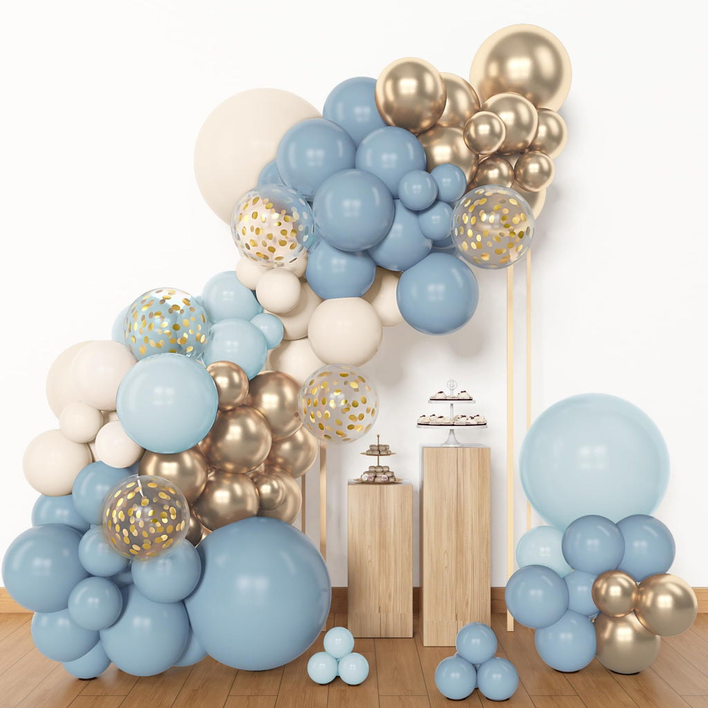 Dusty blue, white, and gold balloon arch with confetti balloons, displayed with cupcakes on wooden stands.