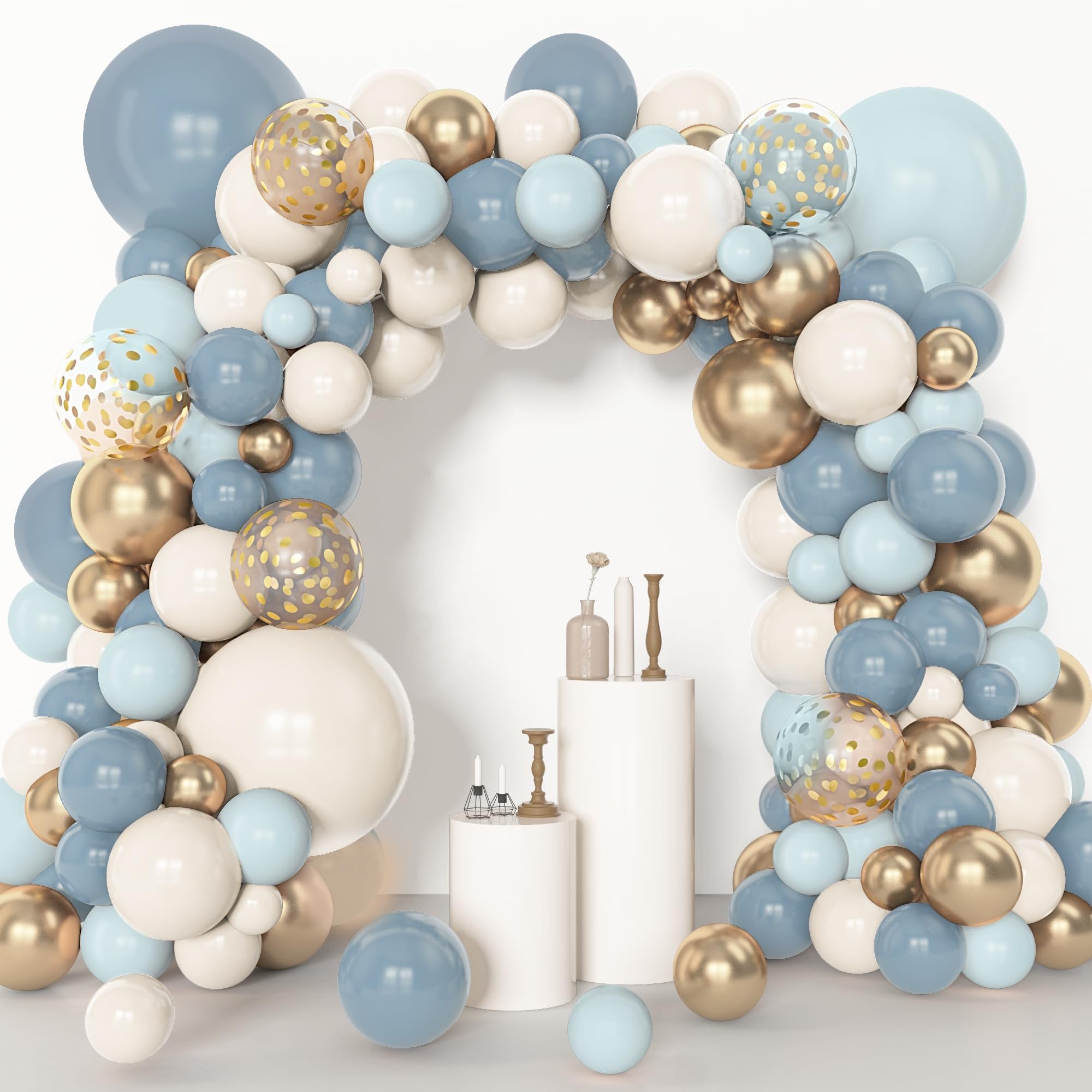 Dusty blue, white, and gold balloon arch with clear balloons featuring gold confetti, arranged around a white backdrop with pedestals.