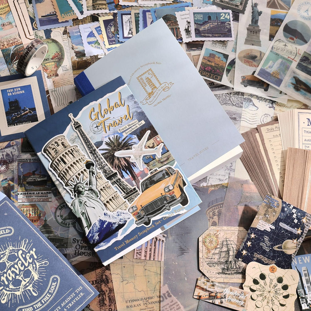 Travel-themed scrapbook supplies including notebooks, stickers, washi tape, and papers scattered on a surface.