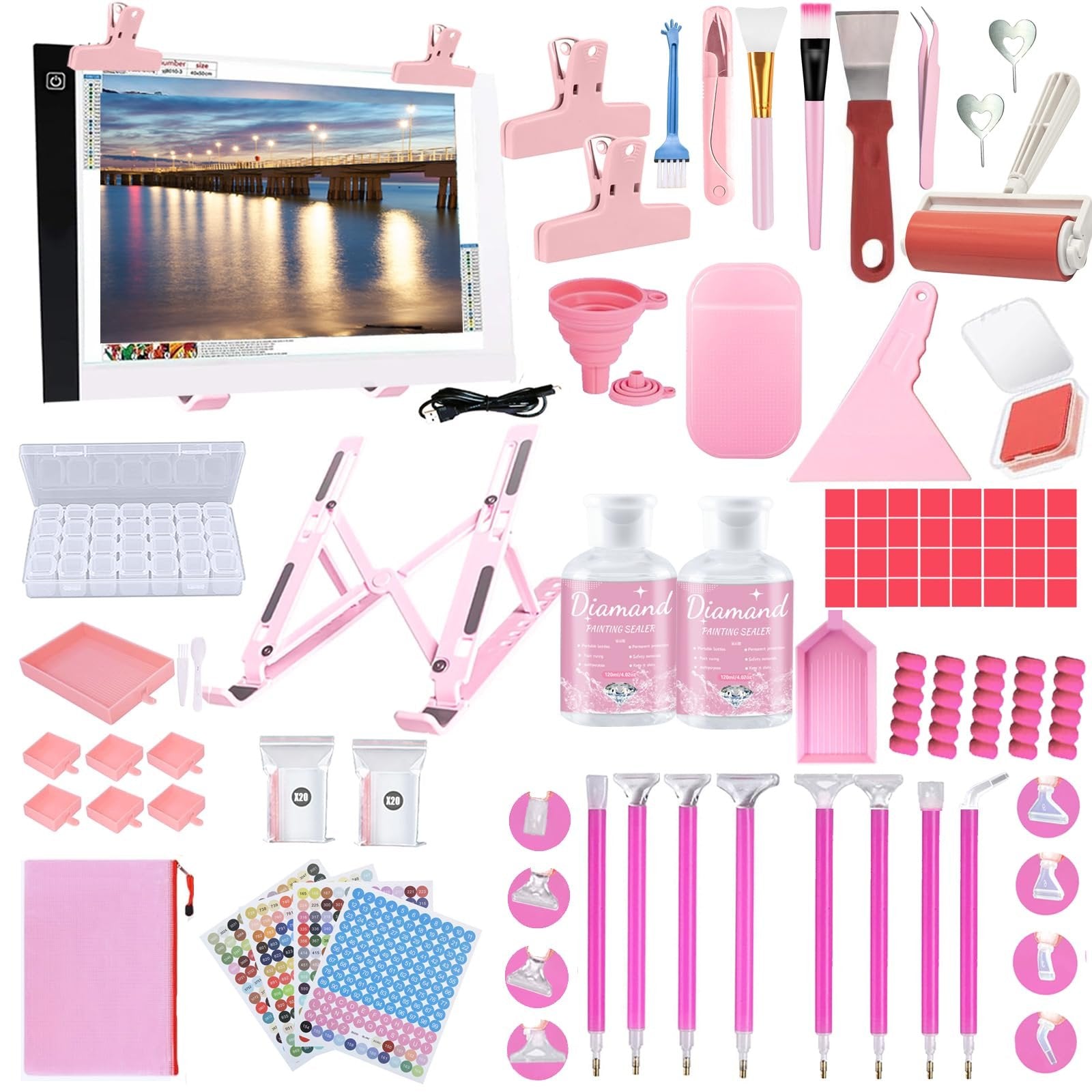 Diamond art accessories kit with light pad, sealer glue, pens, storage box, and various tools laid out.