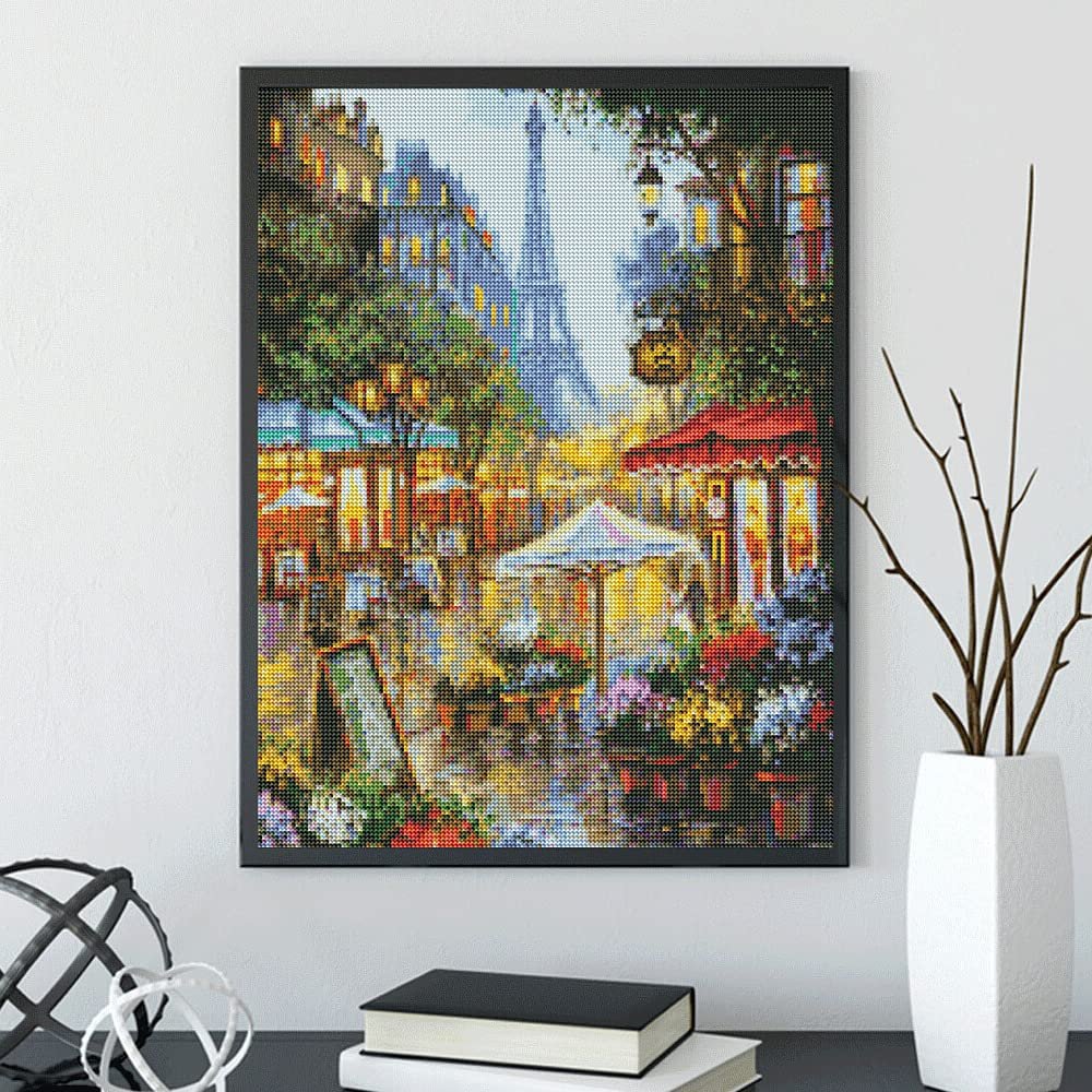 Diamond painting kit depicting a Parisian street scene with the Eiffel Tower in the background, displayed in a black frame.