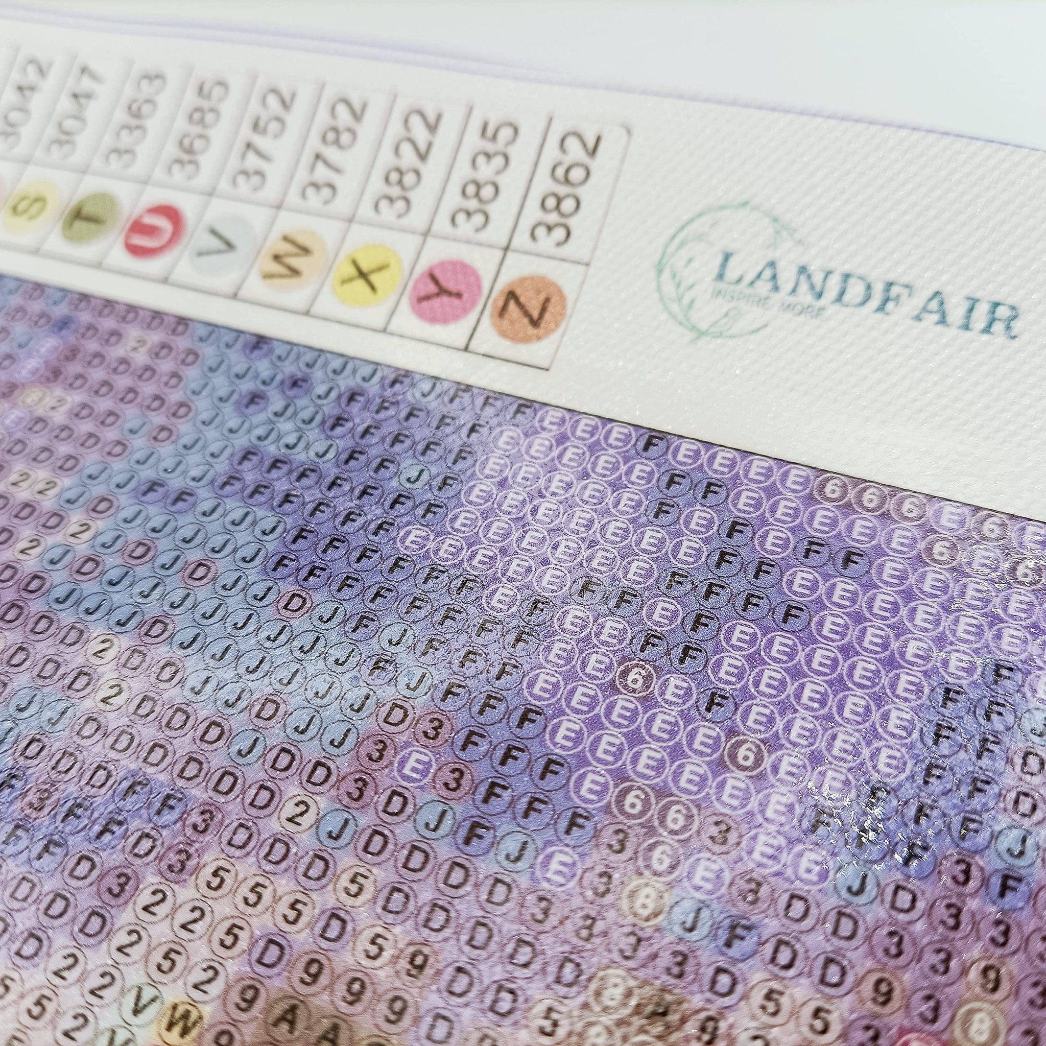 Diamond painting canvas with color code chart and logo, showing printed symbols on canvas.