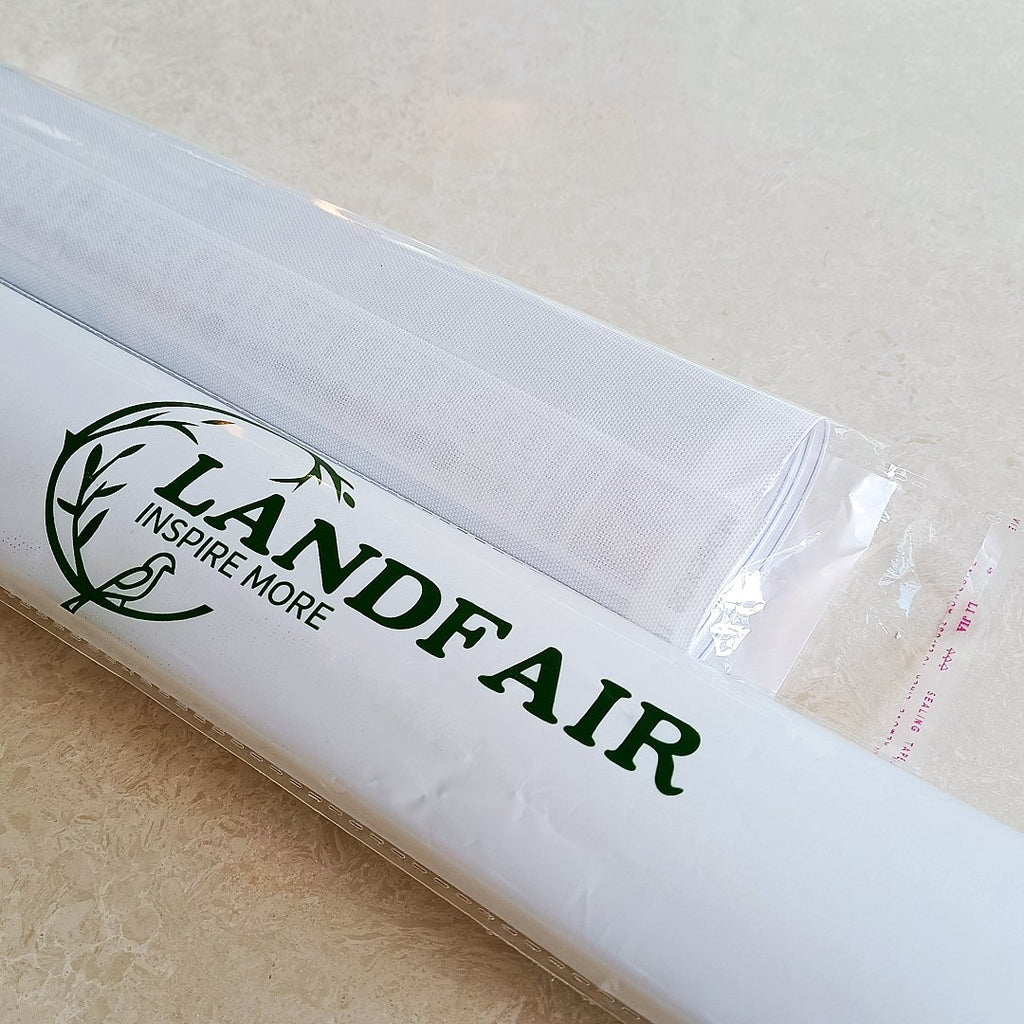 Two rolled white canvases in plastic packaging, one with a green logo and text.
