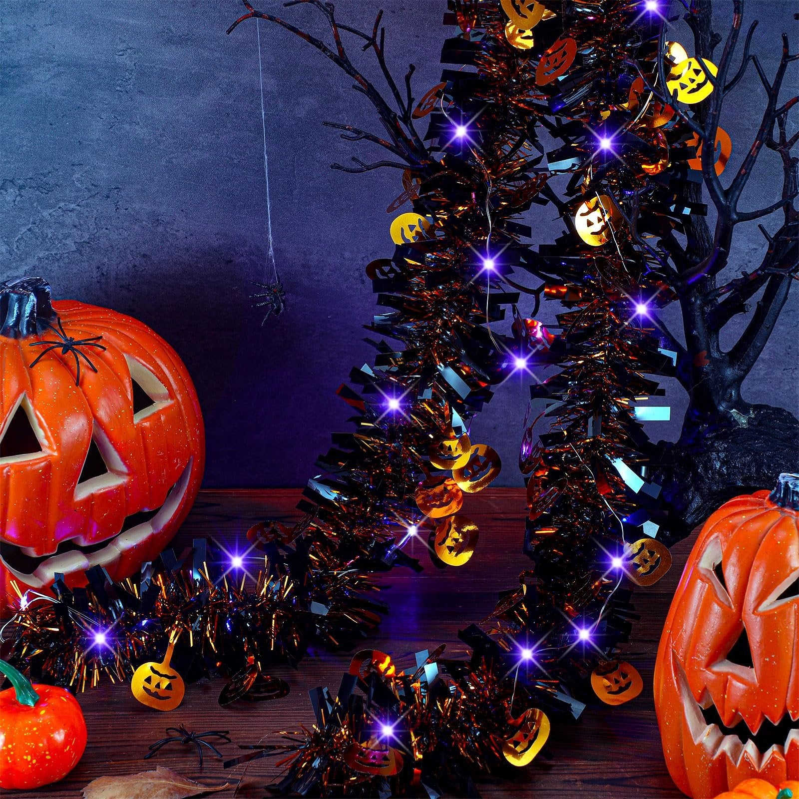 Halloween tinsel garland with purple LED lights and pumpkin sequins, displayed with jack-o'-lanterns and a spider.