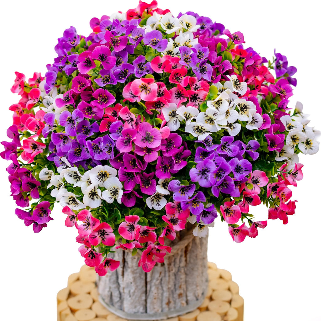 Artificial flowers in pink, purple, and white in a textured pot on a wooden stand